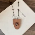 Detailed view of a brown leather glasses clip necklace featuring a cute leopard print bear. - Bear Style / Brown