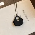Detailed view of a unique black hand-woven mini bag pendant on a long black sweater chain - Necklace-Black