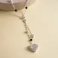 Close-up detail of a vintage silver-toned heart pendant with pearls and bow decoration - Heart Bowknot Style / Silver