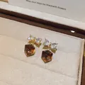 Detailopname van Maillard vintage oorknopjes met zirkoonstrik en bruine kubushanger - Oorknopjes