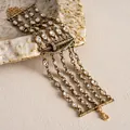 Nahaufnahme einer goldenen mehrlagigen Halskette mit diamantbesetztem Lippenmotiv - Armband / Gold