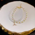 Elegantes doppellagiges Perlenarmband mit goldenem Meerjungfrauenschwanz - Fischschwanz Anhänger Zweireihige Kunstperle Stil (39) / Gold-Weiß