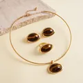 Gedetailleerd overzicht van een vintage gouden sieradenset met ovale tijgeroog-effect harsen stenen - Choker Oorbellen Ring Set / Zilveren naald / Goud-Donkere Koffie