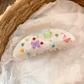 Detalle de una pinza para el pelo de acrílico iridiscente con mariposas y piedras strass - Estilo de Mariposa Iridiscente