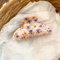 Vista detallada de una pinza para el cabello de acrílico con motivos florales. - Estilo Floral Púrpura