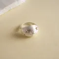 Makroaufnahme eines gebürsteten Silbersternrings mit funkelnden Zirkonia-Steinen. - Silber