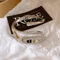 Close-up of silver heavy-duty twisted hollow bangle with high-polish metallic finish. - Polished Style (1#)