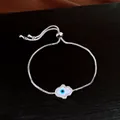 Vue macro détaillée d'un bracelet Hamsa en argent avec un œil protecteur et des zircons - Argent-Œil