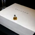 Gros plan d'une boucle d'oreille à vis avec zircone jaune étincelante sur boîte - 7mm / Jaune
