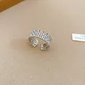 Detailed macro view of a silver-toned hollow lace open ring with pearls and zircons - Silver
