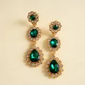 Gros plan de boucles d'oreilles vintage avec pierres en goutte vert émeraude et strass clairs - Vert