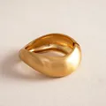 Detail macro view of matte gold irregular twisted geometric bangle on textured surface - Twisted Style / Matte Gold