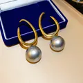 Detaillierte Nahaufnahme von französischen Vintage-Goldohrringen mit grauen Perlen - Gold-Grau