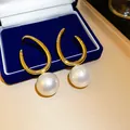 Detaillierte Makroansicht französischer Vintage-Goldschmuck-Ohrringe mit großen weißen Perlen - Gold-Weiß