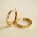 Detaillierte Nahaufnahme von glänzenden goldfarbenen Creolen im geometrischen Design - Glatt Klein / Gold