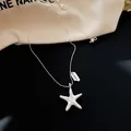 Detailed view of a silver starfish pendant necklace with LUCKY engraved tag accent - Crumpled Starfish Pendant Style (HN13597) / Silver