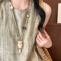 Artistic wooden cat pendant necklace on a long leather cord worn over a green linen dress - Necklace-White-Coffee