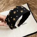 Vista detallada de las estrellas doradas y remaches en esta diadema de tela negra de moda - Diadema-Negro