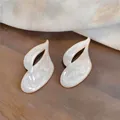 Detailed view of elegant white pearlescent drip oil leaf-shaped silver needle stud earrings - Abstract Leaf Style / Pearl White