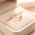 Detailansicht eines 1 mm dünnen vergoldeten Rings mit einem funkelnden rosa Zirkon. - Größe 5 / Gold-Rosa Zirkonia