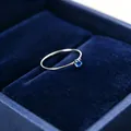 Detailansicht eines feinen 1mm Silberrings mit einem funkelnden blauen Edelstein im Samtetui. - Größe 5 / Silber-Blauer Zirkonia