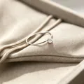 Nahaufnahme eines 1 mm ultradünnen Titanstahlrings mit funkelndem Zirkon-Solitär. - Größe 5 / Silber-Weiße Strasssteine
