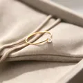 Detailansicht eines 1 mm dünnen Goldrings aus Titanstahl mit runden Zirkonia - Größe 5 / Gold-Weißer Zirkonia
