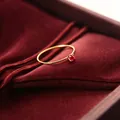 Nahaufnahme eines 1mm Titanstahlrings mit funkelndem rotem Zirkonia-Stein - Größe 5 / Gold-Roter Zirkonia