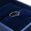 Nahaufnahme eines 1 mm goldfarbenen Titanstahlrings mit blauem Zirkonia-Stein in Box - Größe 5 / Gold-Blauer Zirkonia