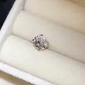 Gros plan d'une pierre ronde facettée dans une monture de boucle d'oreille en acier - 8mm / Blanc