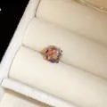 Détail macro d'une boucle d'oreille en cristal irisé dans un écrin à bijoux en velours beige - 8mm / Rose