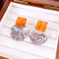 Close-up of vintage resin stud earrings with amber square and marble circular pendants - Geometric Patchwork Style / Coffee