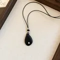 Gedetailleerde weergave van de minimalistische zwarte druppelhanger met zwart koord - Zwart