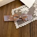 Nahaufnahme einer eleganten braunen Schleifen-Haarspange mit funkelnden Strass-Akzenten. - Entenschnabel-Clips / Entenschnabelklammer - Kaffee