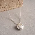 Dettaglio del ciondolo a cuore in argento con fori a pois su una catena a serpente - Cuore / Argento