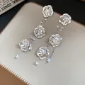 Detailansicht eleganter silberner Metallblumen-Ohrhänger mit Perlenverzierung. - Silber (Silberstift)