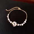 Gros plan d'un bracelet élégant plaqué or 18 carats avec breloques lune et cœur en zircon - Bracelet Plaqué Or Véritable / Or