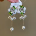 Detailansicht von Vintage-Ohrringen im Barockstil mit Resiblüten, Kristallen und Perlen - Weißes Blumen Schmetterling Modell / 925 Silberstecker / Gold