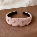 Close-up of a pink padded headband with gold star studs and a high skull top design - Headband / Pink