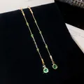 Detailed macro view of elegant long tassel earrings with green crystals on black velvet - Water Drop Tassel Style (HE35674) / Silver / Gold-Green