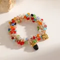 Close-up view of a colorful beaded elastic bracelet featuring gold heart and black charms. - Heart Half-Oval Pendant (M201) / Colorful