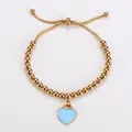 Detailansicht eines goldenen Perlenarmbands mit hellblauem Herzanhänger - Gold Blau