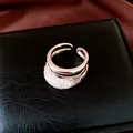 Gros plan détaillé d'une bague double couche en or rose avec maille en zircone étincelante - Or Café Léger