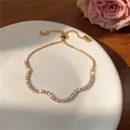 Elegant goudkleurig gegolfd armbandje met fonkelende zirkonia voor luxe uitstraling - Golf Geometrisch / Verstelbaar / Goud
