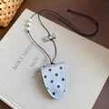 Detailed view of polka dot leather magnetic eyewear clip with white beads and bow - Silver
