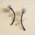 Détail macro de boucles d'oreilles florales avec tiges en cuir noir et cristaux brillants - Aiguille en Argent-Blanc-Café