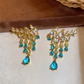 Detailed macro view of gold-plated water-drop tassel earrings with gradient blue zircons - Water Drop Tassel Stud Earrings (HE35638) / Gold-Blue