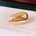 Nahaufnahme eines polierten goldfarbenen Rings in Tropfenform in einer Schmuckschatulle - offener Ring / Gold