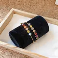 Nahaufnahme eines mehrlagigen Goldarmbands mit bunten quadratischen Zirkonia-Steinen - Mehrfarbiger Geometrischer Zirkonia Mehrschichtiger Offener Armreif (6) / Gold-Mehrfarbig