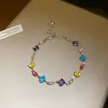 Close-up detail of a silver-tone chain bracelet featuring vibrant square and oval crystals - Silver